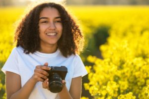 donna con macchina fotografica in un bellissimo prato fiorito - content marketing per ecommerce